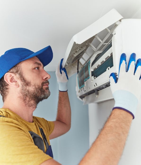 Repairman cleaning and fixing indoors ac unit