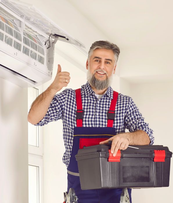 Technician man from ac service installs good modern air conditioner in the house